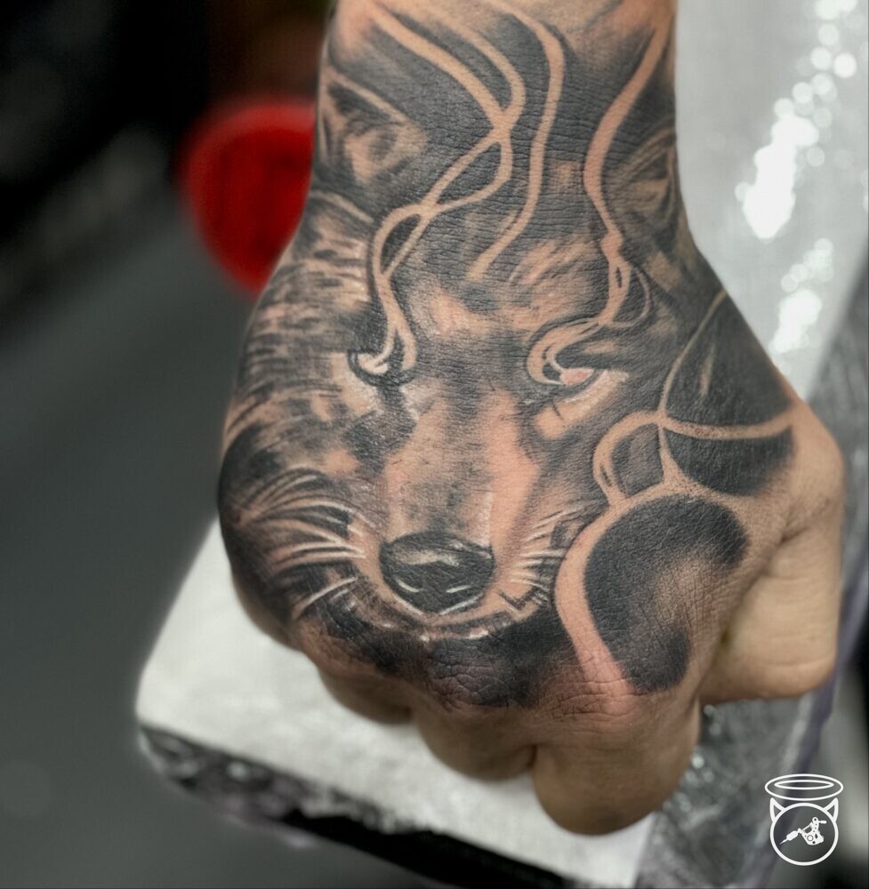 Wolf hand tattoo done at On the Road Tattoo New Ramsey Tattoo Studio